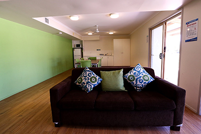 Room with kitchen, couch and table with chairs.